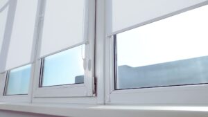 white fabric blind closing on window