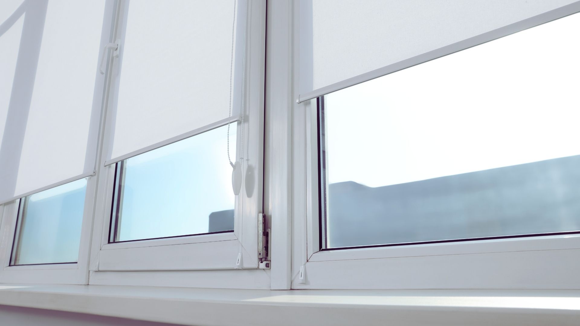white fabric blind closing on window