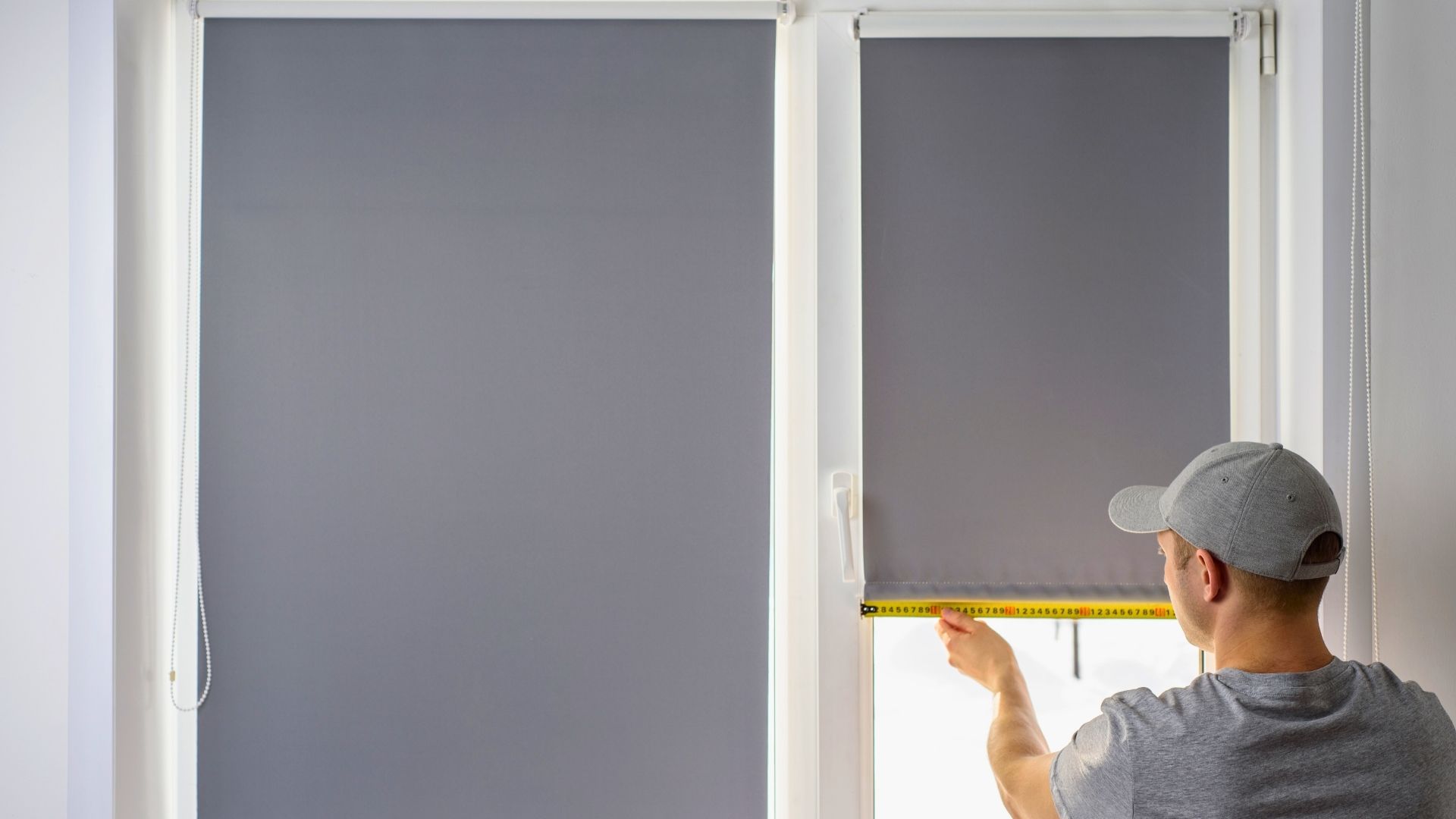 energy-efficient blinds in michigan man measuring window for blind installation gray blinds
